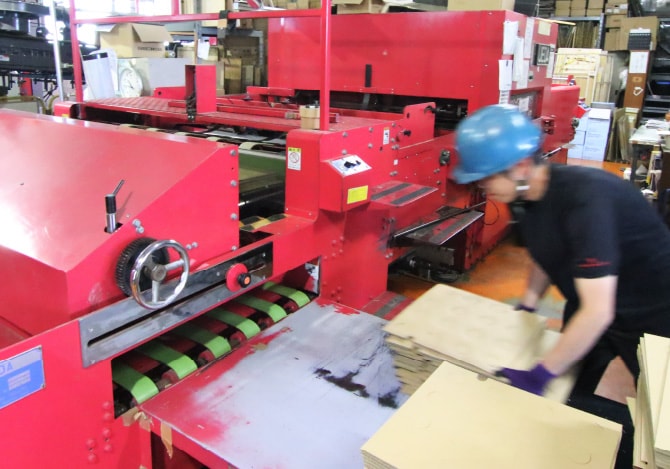 段ボールの製造ラインで作業するスタッフ